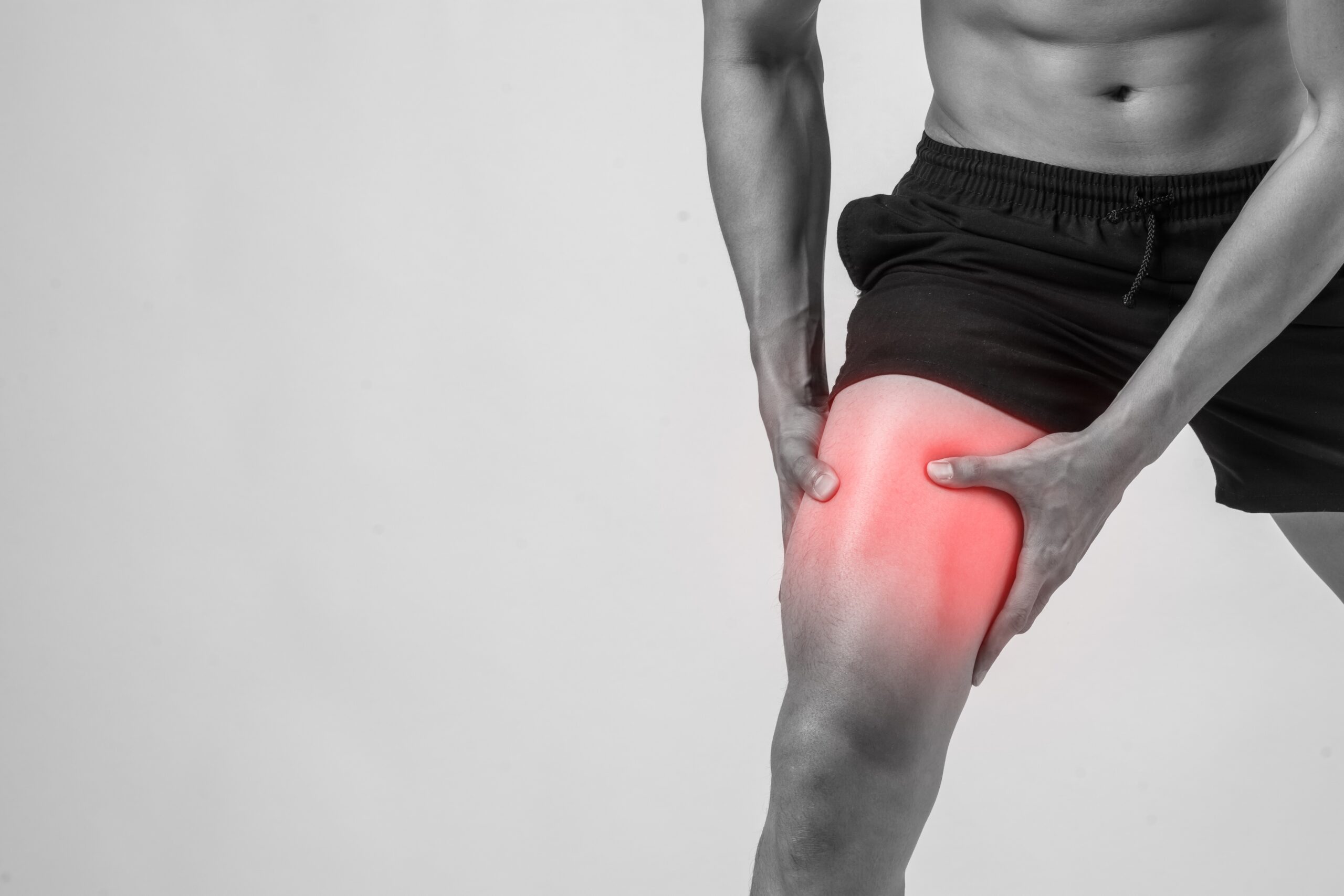 young sport man with strong athletic legs holding knee with his hands pain after suffering ligament injury isolated white 1 scaled